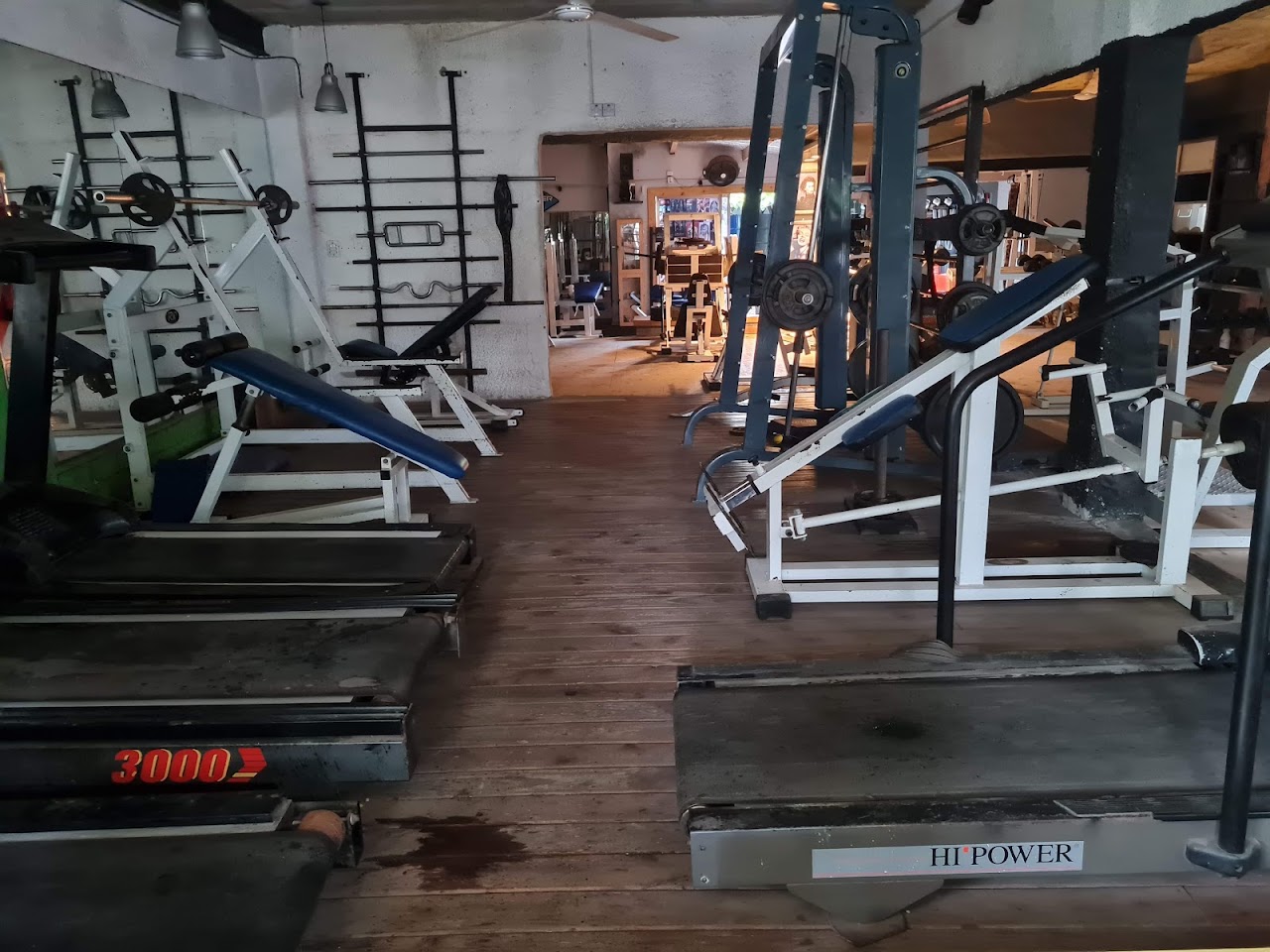Interior del gimnasio Triple X con máquinas de musculación y pesas libres